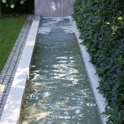 langes, schmales Wasserbecken mit Wasserspeier