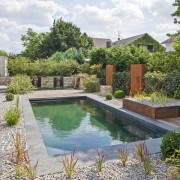 Wasser, Granit und Cortenstahl in Verbindung mit einem Fertigpoolbecken sieht sehr ästhetisch aus